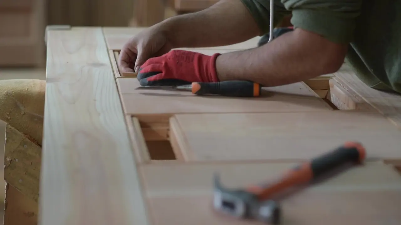 Detalle de trabajo con formón sobre un panel de madera