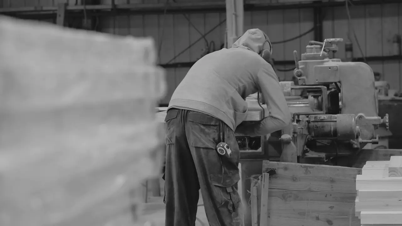 Carpintero trabajando madera en una máquina del taller